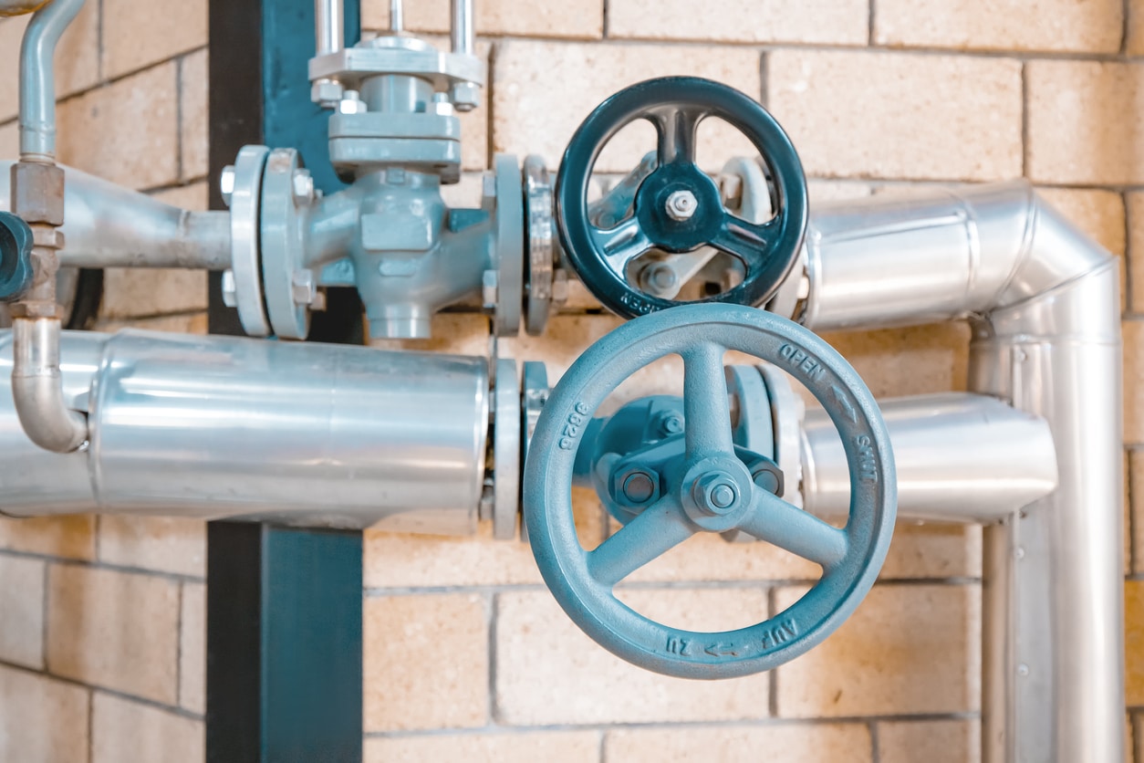 gas line pipes positioned in front of brick wall